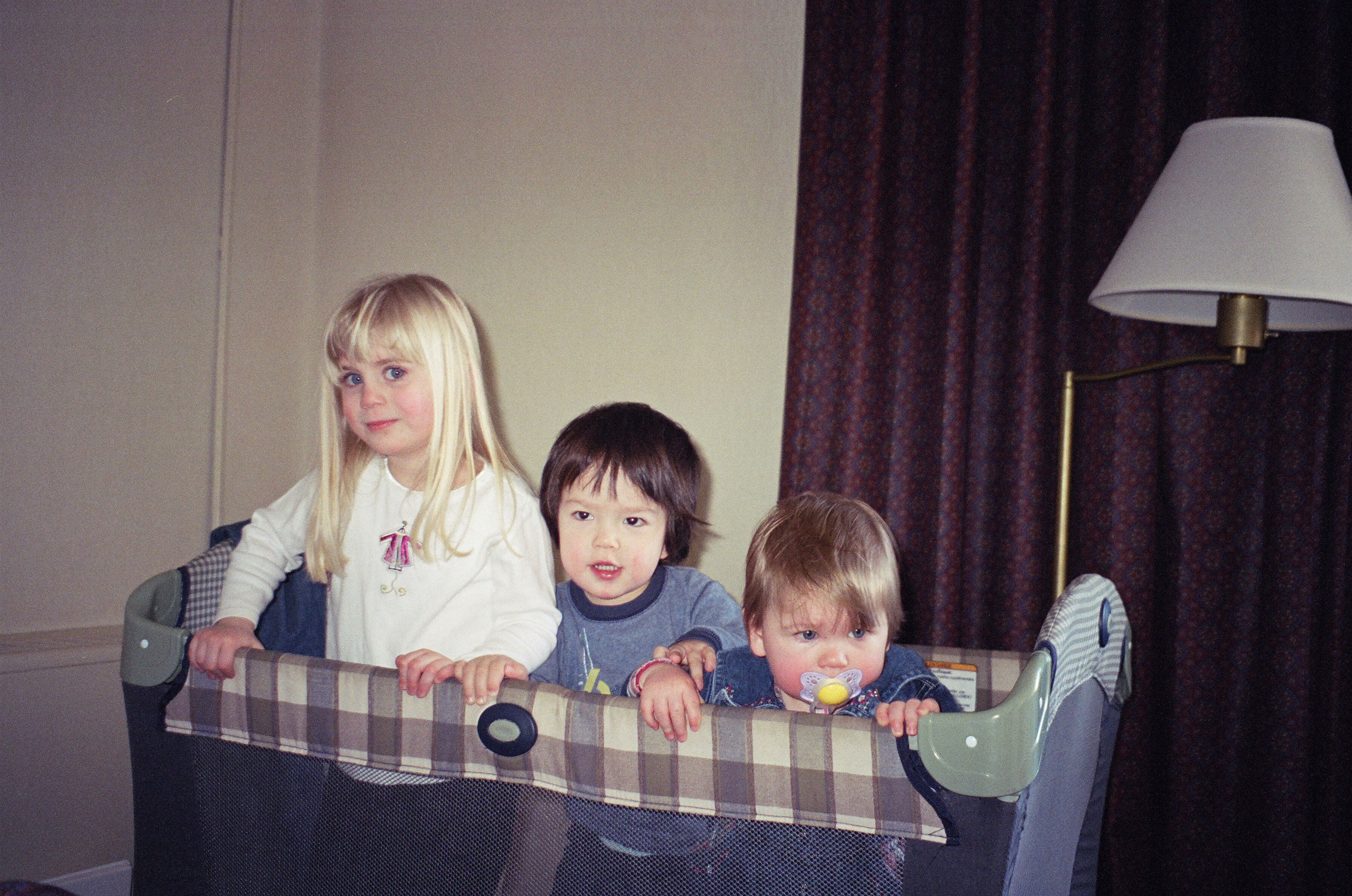 Picture of G, SJ and LM standing in a crib in Schenectady